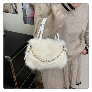 Dettaglio della borsa di peluche bianca con catena di perle portata da una modella