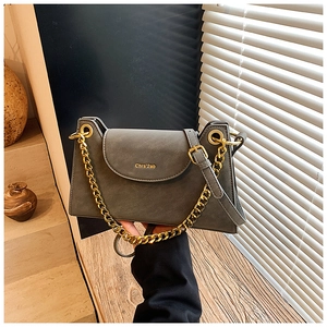 Détail du sac à main en cuir gris mat avec chaîne dorée et finitions de marque