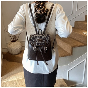 Dettaglio dello zaino vintage in pelle marrone con patta leopardata sulle spalle