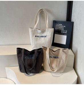 Three minimalist canvas tote bags in white, black and khaki with comfortable handles