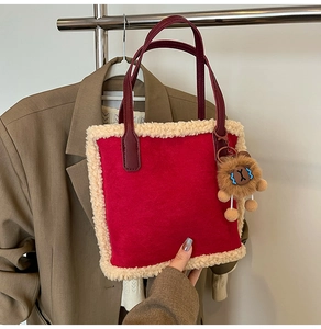 Détail du sac cabas rouge avec bordure en fausse fourrure crème et breloque lion