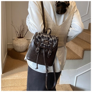Dettaglio del mini zaino vintage con patta leopardata e pelle marrone su una modella