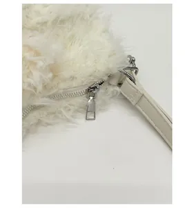 Detailed close-up of smooth silver metal zipper and white plush faux fur bag texture