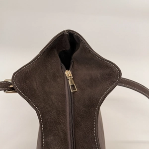 Detail of premium brown faux suede tote with golden zipper and white contrast stitching