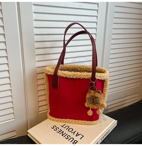 Détail du sac fourre-tout rouge en peluche avec bordure beige et breloque ours mignon