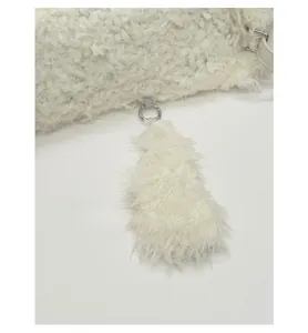 Detail of white fluffy plush bag featuring a soft faux fur tail pendant and metal ring