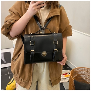 Detailed view of the black retro satchel with golden metal buckles and leather texture