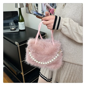 Dettaglio della borsa in ecopelliccia rosa con catena di perle e sottili manici in pelle