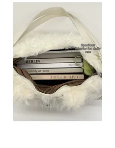 Spacious interior of white plush tote bag filled with books and a green pouch