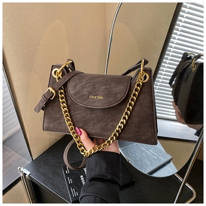 Détail du sac à bandoulière rétro marron foncé avec chaîne dorée et logo en métal