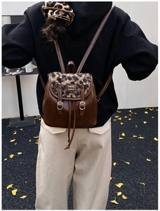 Zaino in pelle marrone con patta leopardata e chiusura a coulisse in ambiente esterno