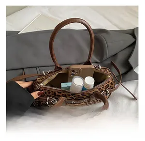 Detail view of the leopard print handbag interior showing daily essentials and lining
