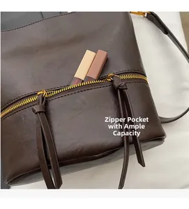 Détail du sac seau marron vintage montrant la poche zippée avec glands en cuir