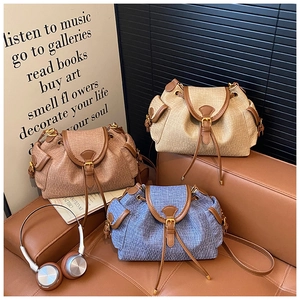 Close-up of three vintage canvas bucket bags with drawstring and leather trim