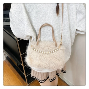 Dettaglio borsa di peluche bianco crema con catena di perle e tracolle in pelle
