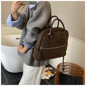 Détail du sac à dos en similicuir marron avec fermetures éclair et grand compartiment