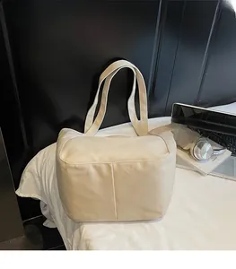 Close-up of durable cream canvas tote bag with clean stitching and wide shoulder straps