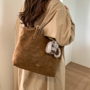 Brown faux suede tote bag featuring a cute plush bunny charm and gold brand logo detail