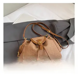Detail shot of the brown woven texture and leather drawstring on this retro bucket bag