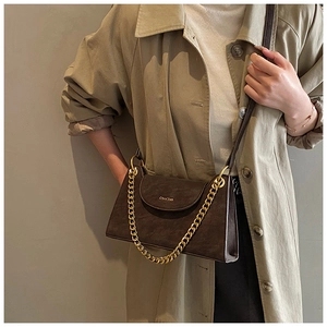 Détail du sac bandoulière vintage marron avec chaîne dorée et logo de marque