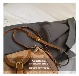 Detail showing the adjustable leather shoulder strap with golden metal buckle for this bag
