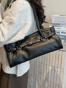 Sac baguette rétro en cuir noir avec boucle argentée et fine bandoulière sur mannequin