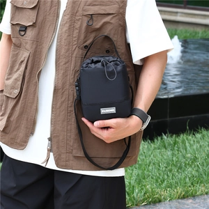 Detail van de zwarte tactische nylon tas met trekkoordsluiting en modepatch op de voorkant