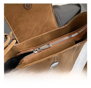 Close-up of premium silver zipper and magnetic snap on brown suede bucket bag