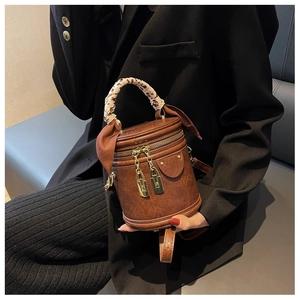 Retro brown bucket bag with leopard scarf handle and gold hardware shown on a model