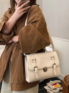 Retro cream messenger bag with metal clasp and shoulder strap for casual commute