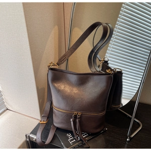 Détails du sac seau vintage marron foncé avec fermetures éclair et doubles pompons