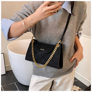 Détail du sac bandoulière noir mat avec chaîne dorée et texte de marque élégant