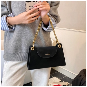 Gros plan sur un sac à bandoulière noir mat avec chaîne dorée et détails du logo