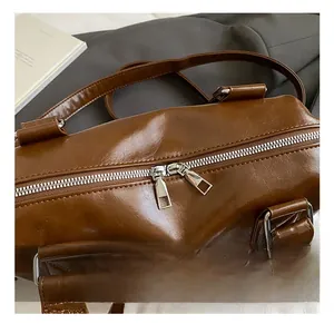 Detail showing silver double zipper hardware and stitching on vintage brown tote bag