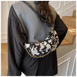 Detail of hobo crossbody bag in black and white jacquard fabric with gold chain accent