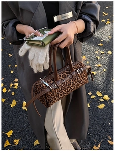 Leopard print bowling bag with leather trim and adjustable strap shown in street style