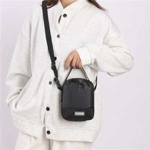 Detail van de zwarte nylon crossbodytas met trekkoord en een verstelbare schouderriem