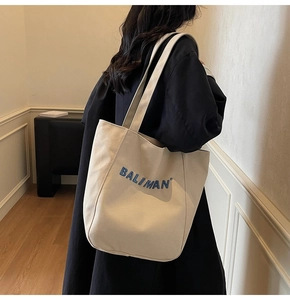 Detail of blue BALIMAN embroidery on a premium cream canvas tote bag for women