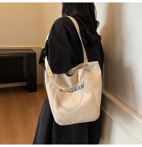 Detail of beige canvas tote bag with BALIMAN logo showing texture and large capacity