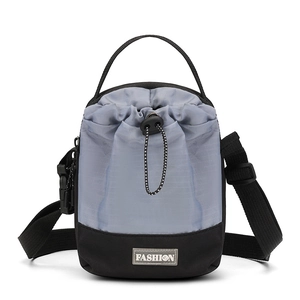 Detail van grijs en zwarte nylon crossbodytas met trekkoordsluiting en modieus label