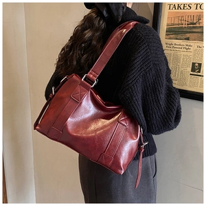 Model wearing a vintage burgundy tote bag in oil wax leather texture for stylish commuting
