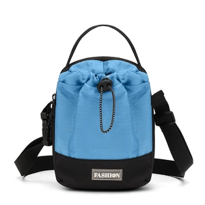 Detail van blauwe nylon crossbodytas met trekkoordsluiting en modieus label