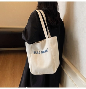 Close-up of white canvas tote bag with blue Baliman lettering and durable straps