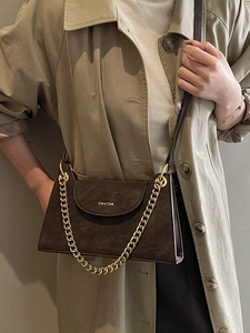 Sac bandoulière vintage en cuir marron avec chaîne dorée sur mannequin en trench