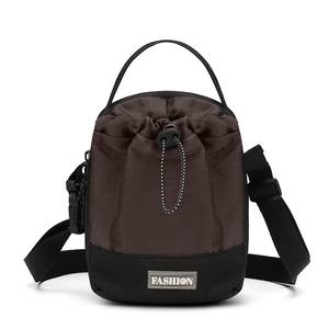 Detail van multifunctionele crossbody emmertas met trekkoordsluiting en modieus leren label