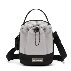 Detail van de grijze outdoor crossbodytas met trekkoordsluiting en modelabel