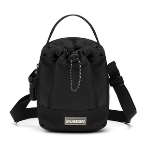 Detail van zwarte nylon bucket bag met trekkoord, verstelbare riem en mode-etiket