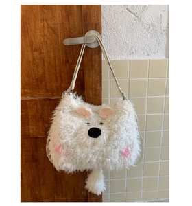 Close-up of white fluffy plush bag showing soft faux fur texture and cute cartoon animal face