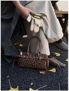 Close-up of leopard print Boston bag with brown leather accents and silver hardware