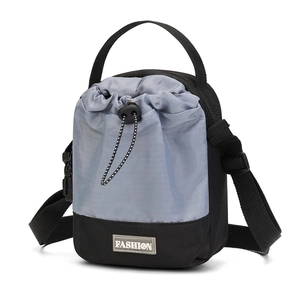 Detail van outdoor crossbodytas met blauw en zwart trekkoord en modieus embleem erop